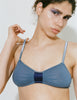 A close-up of a model wearing the Araks Uma bralette in Shadow