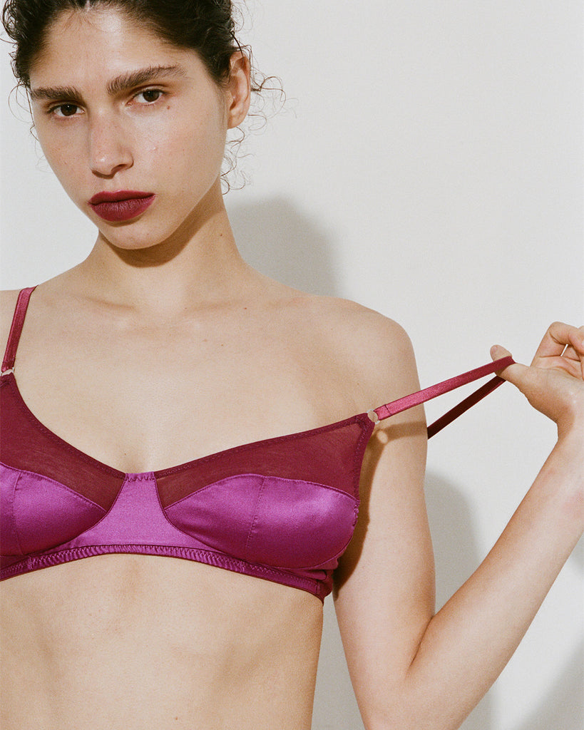 A model wearing Willow bralette in Raspberry against a plain light gray background.