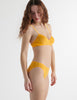 Side view of the woman wearing antonia orange marigold cotton bra and isabella panty