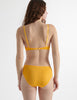 Back view of the woman wearing antonia orange marigold cotton bra and isabella panty