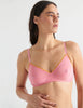 Detail view image of model wearing pink bralette with yellow trim. 