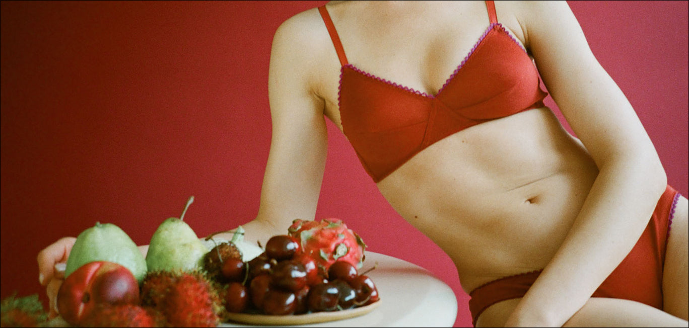 A woman wearing the Antonia Bralette in red organic cotton.