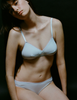 A model in the araks organic cotton antonia bralette and isabella panty in fondant blue