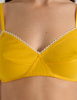A model in the araks organic cotton antonia bralette in pomelo yellow