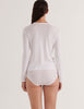 A model in the araks organic cotton sabine long sleeve shirt and isabella panty in white
