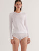 A model in the araks organic cotton sabine long sleeve shirt and isabella panty in white