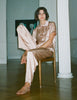 A model in the Araks silk charmeuse shelby pajama top and ally pajama pant in bare silk