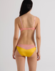 A model in the araks silk beatrice bralette and aaron panty in pomelo yellow