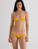 A model in the araks silk beatrice bralette and aaron panty in pomelo yellow