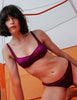 A model in the araks silk penelope bralette and gwyneth panty in cranberry red