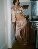 A model in the araks silk charmeuse shelby pajama top and ally pajama pant in bare silk