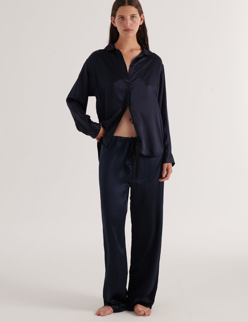 A model in the Araks silk suki pajama top and ally pajama pant in sea silk