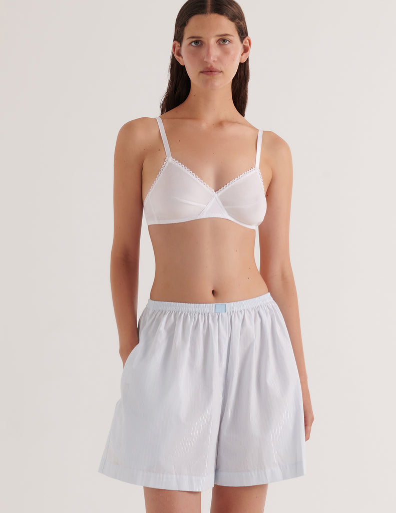 A model in the araks 100% upcycled cotton rose boxer in lurex silver stripe