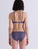 A model wearing Araks Antonia bralette and isabella panty in Violette against a light gray studio background.