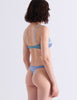 A model wearing Araks beatrice bralette and maya thong in powder against a plain light gray background.