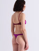 A model wearing Araks Beatrice bralette with Maya thong in Raspberry.