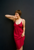 A model posing in an Araks red silk slip