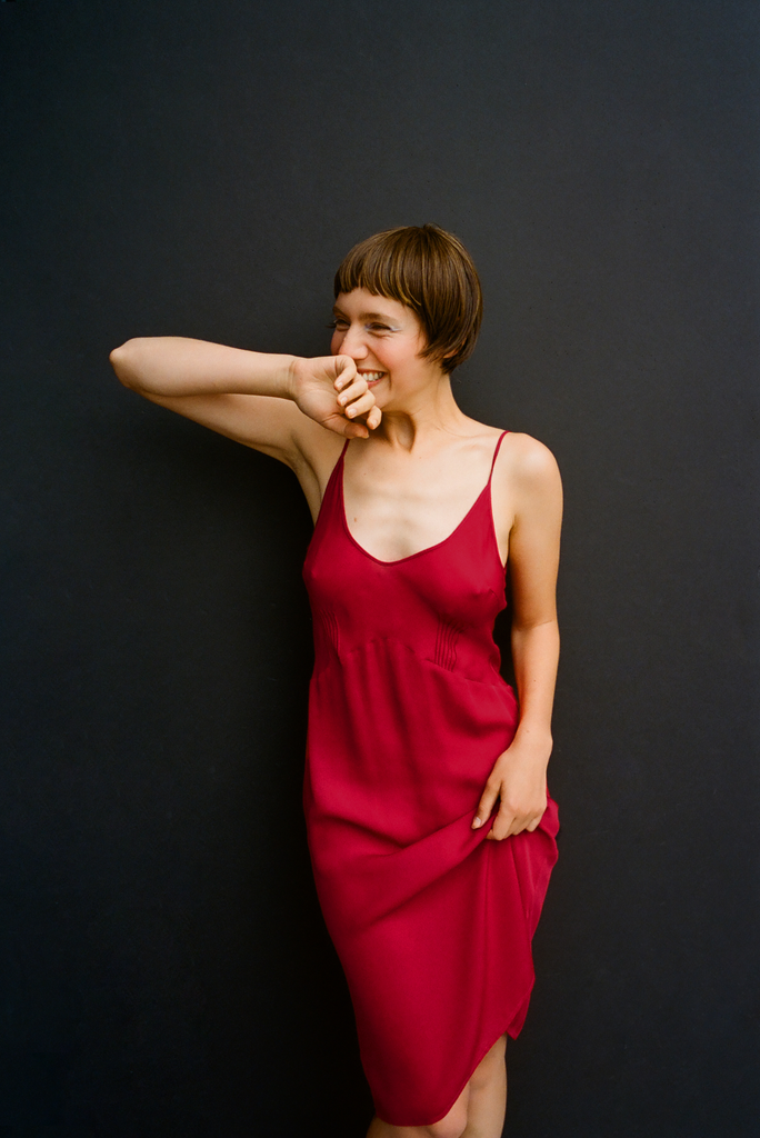 A model posing in an Araks red silk slip