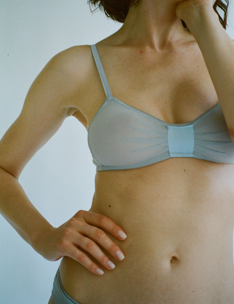 a model in the araks silk and cotton uma bralette in mist grey blue