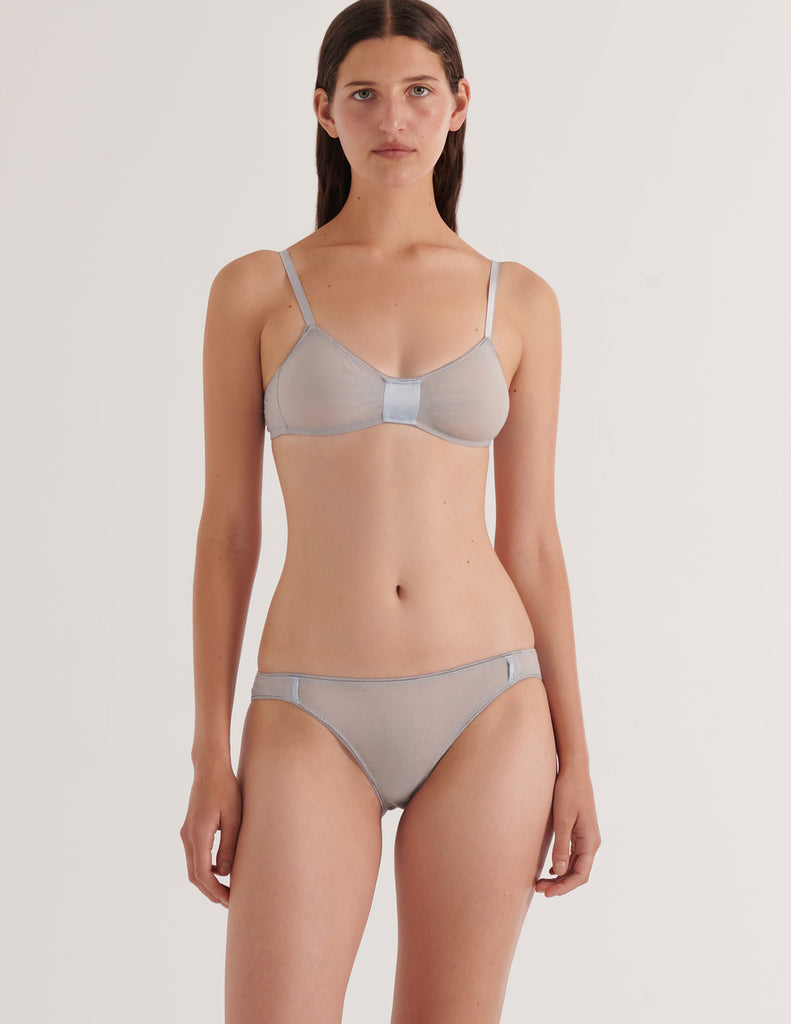 A model in the araks cotton crepe and silk uma bralette and harriet panty in mist grey blue