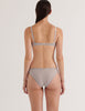 A model from the back wearing the araks cotton silk uma bralette and harriet panty in mist grey blue