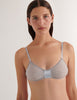 A model in the araks cotton crepe uma bralette in mist grey and blue with a silk inlet