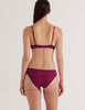 A model in the araks cotton crepe and silk willow bralette and harriet panty in cranberry red