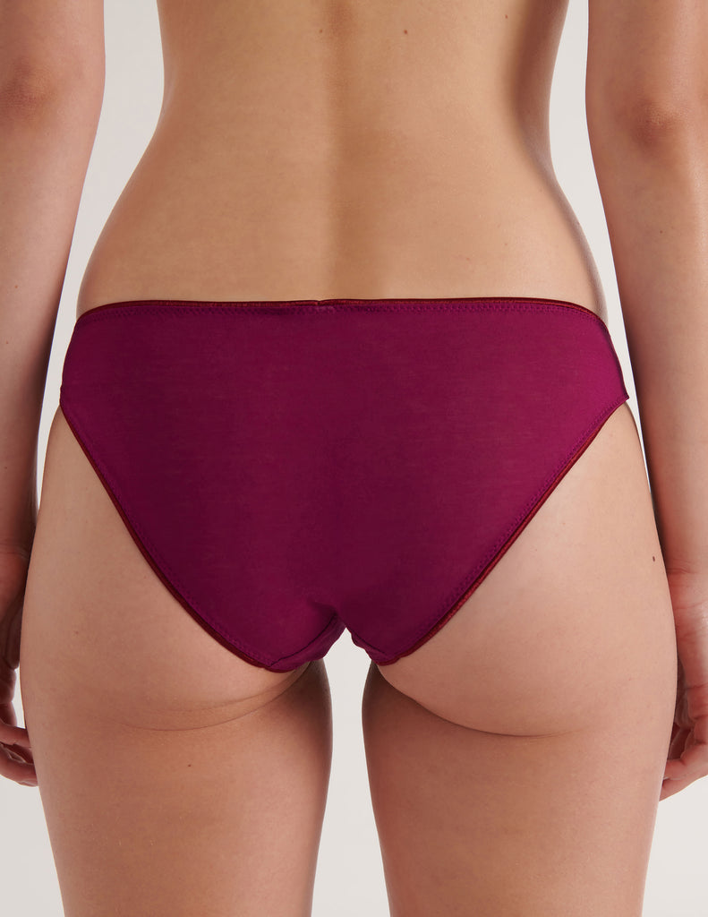 A model in the araks cotton crepe harriet panty in cranberry red