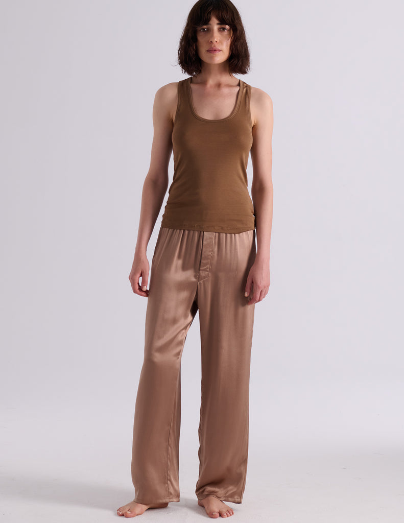 A model posing in the Araks organic cotton brown Terra James Tank. 
