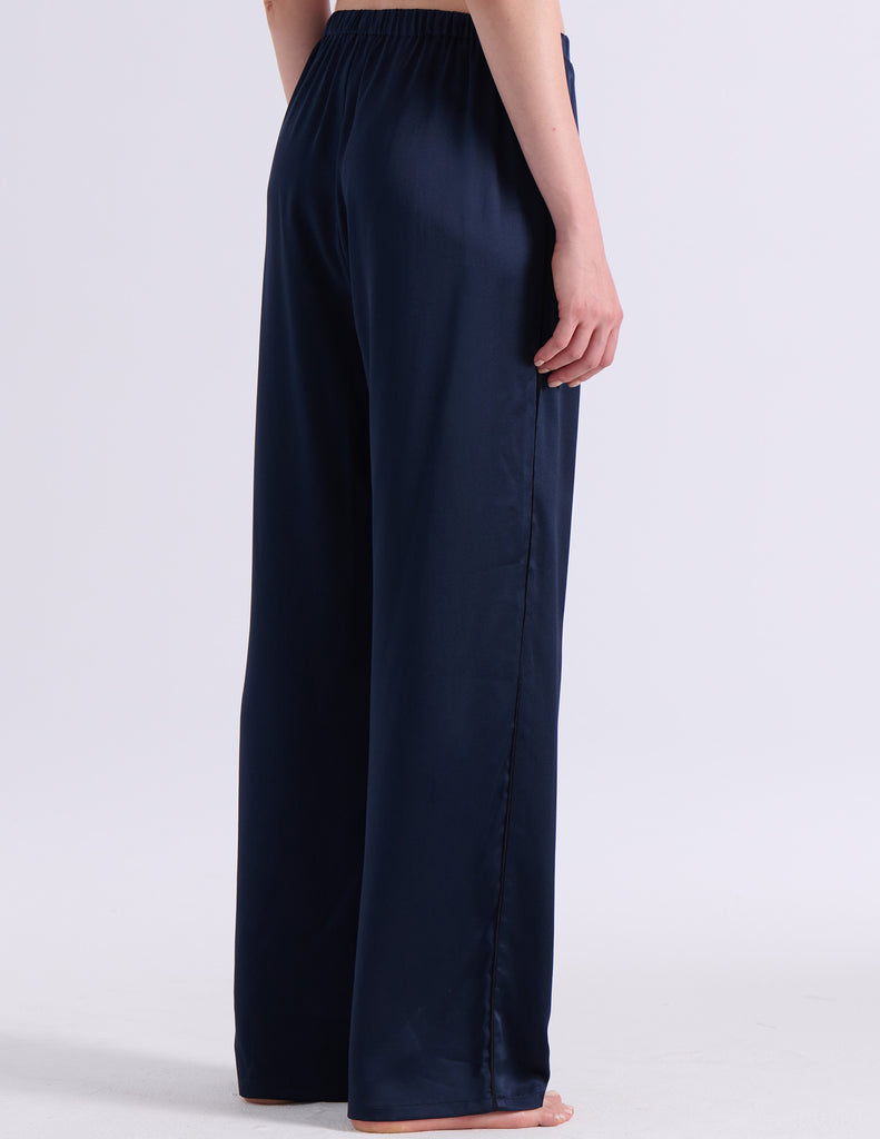 A model wearing Araks silk pajama Viktoria pants in Sea