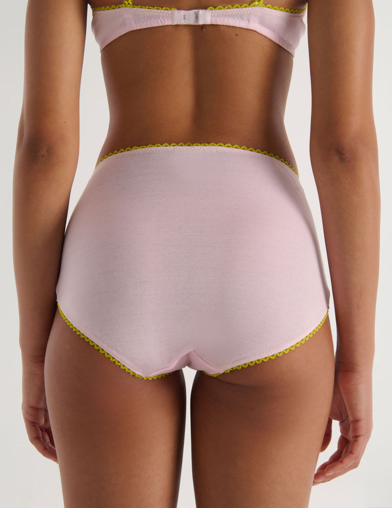 A model in the Araks organic cotton antonia bralette and mabel hipster in confection pink