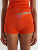 A model in the organic cotton james tank and presley short in marmalade orange