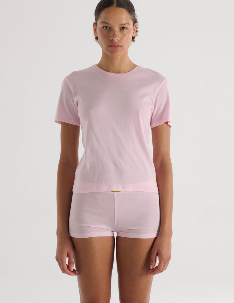 A model in the araks organic cotton tavi short sleeve and presley short in confection pink
