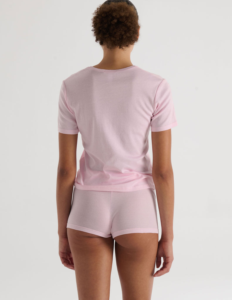 A model in the araks organic cotton tavi short sleeve and presley short in confection pink