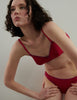 woman wearing araks organic cotton pink antonia bra by white wall 