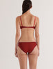 A model in the araks organic cotton antonia bralette and isabella panty in clay red