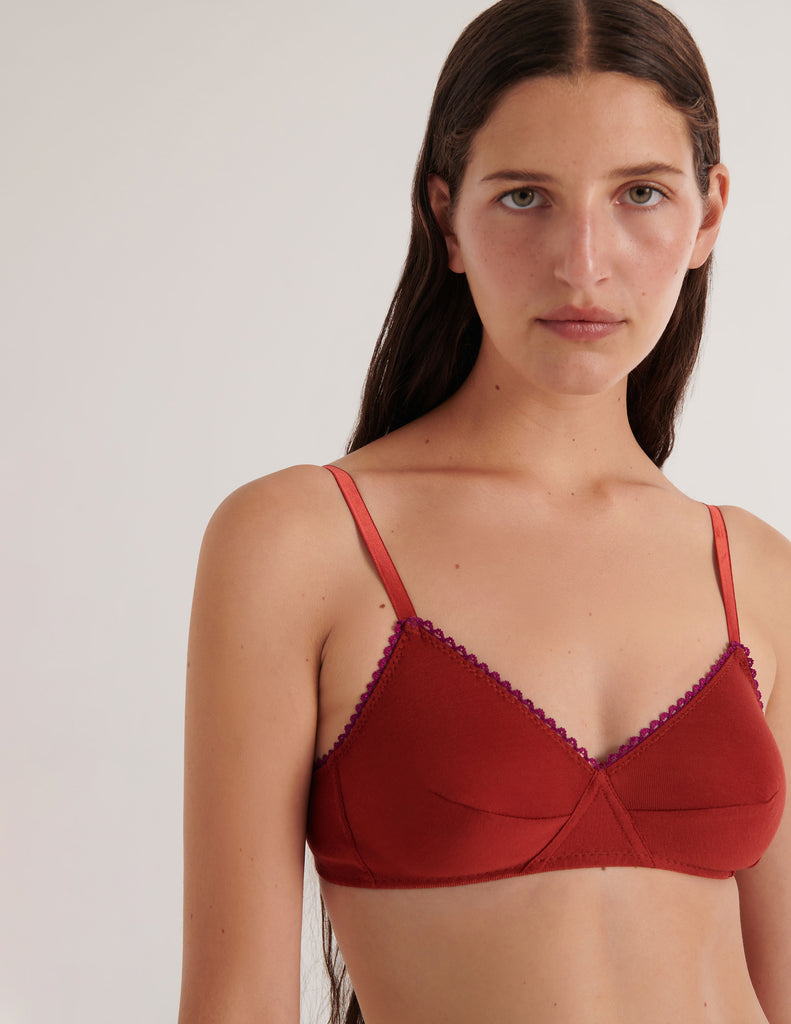 A model in the araks organic cotton antonia bralette in clay red