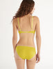 a model in the araks organic cotton antonia bralette and isabella panty in electric yellow