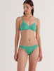 A model in the araks organic cotton antonia bralette and isabella panty in glass green