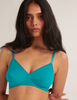 woman wearing ARAKS ORGANIC COTTON antonia bralette in color parrot against white wall 