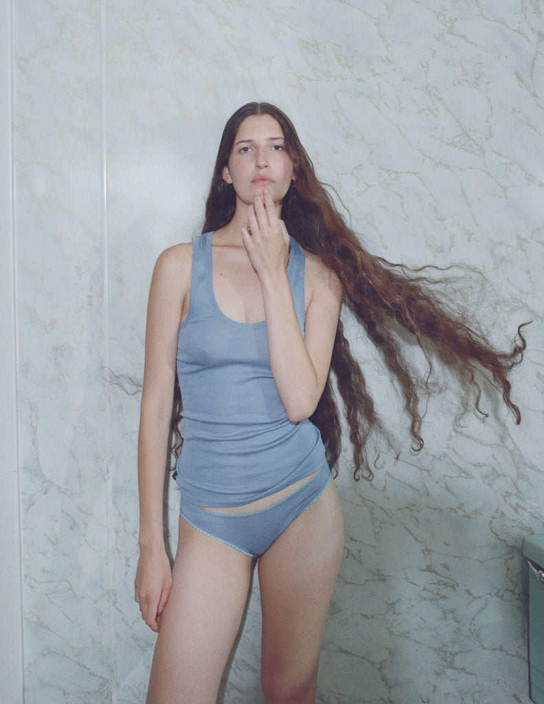 A model in the 100% organic cotton james tank top and isabella panty in feather blue