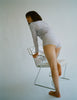A model on a chair in the sabine long sleeve shirt in 100% organic cotton and the presley short in fairy purple