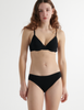 Front view of woman wearing araks organic cotton black isabella panty with black trim, and matching bra.