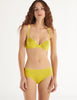 a model in the araks organic cotton sofia underwire bra and josephine hipster in electric yellow