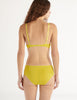 a model in the araks organic cotton sofia underwire bra and josephine hipster in electric yellow