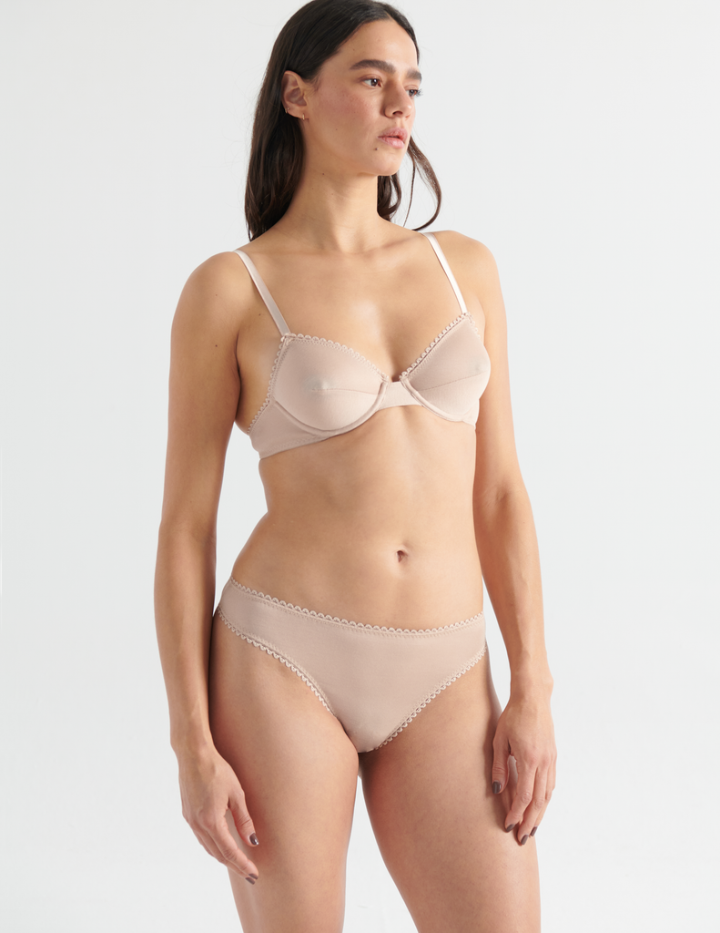 Front view image of model wearing araks organic cotton sand colored sofia underwire bra with matching thong. 
