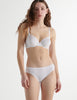 Front view image of model wearing white organic cotton underwire bra with white trim with matching panty. 