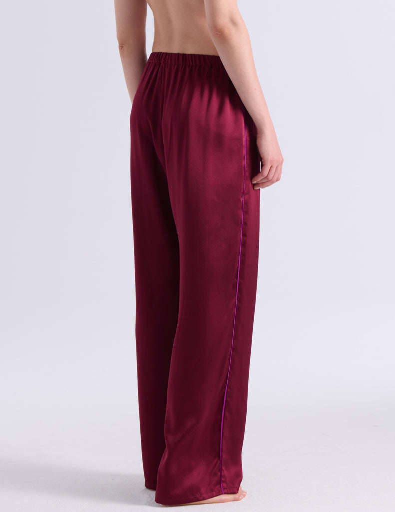 A person shown from the back wearing Araks Viktoria pajama bottoms in Garnet