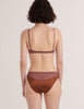 A model from the back in the silk beatrice bralette and aaron panty in noisette brown