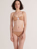 A model in the araks cotton and silk uma bralette and harriet panty in brulee brown